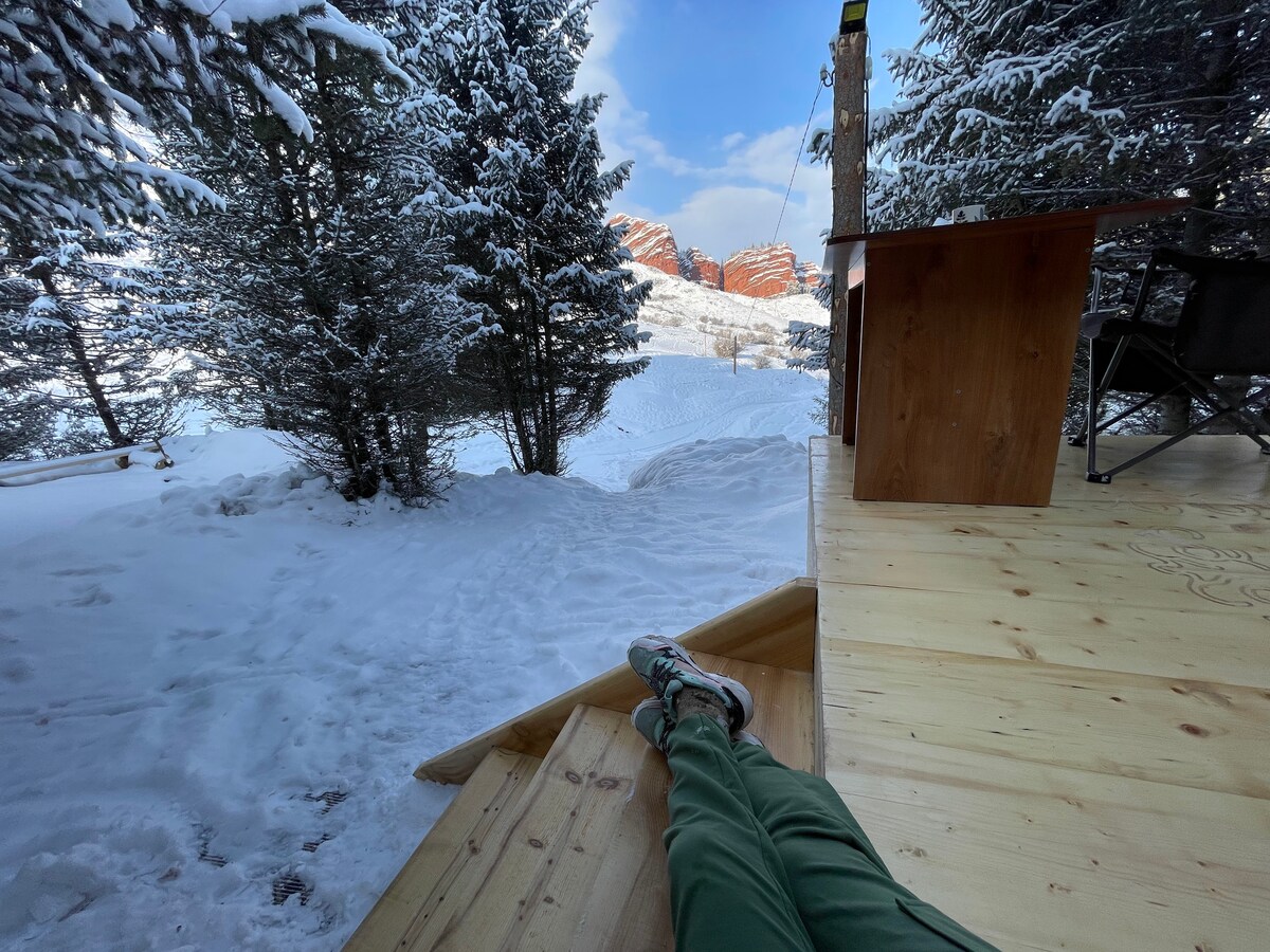 Feet up on the deck facing the snow and the red rocks