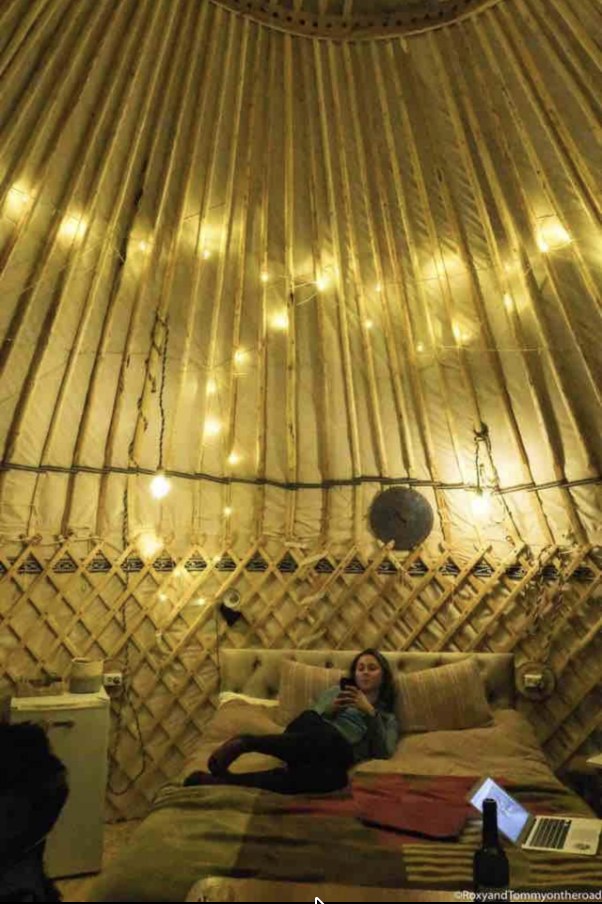 Yurt ceiling crown lit with fairy lights over the bed at night