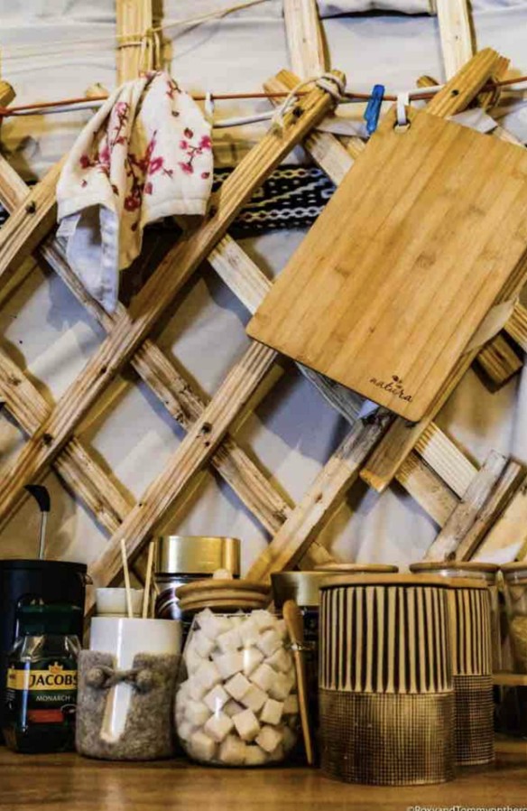 Yurt kitchen shelf with coffee, sugar, spices and a hanging cutting board